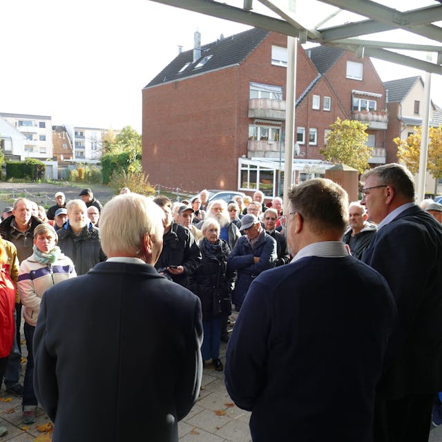 Der ehemalige Niederkasseler Bürgermeister Stephan Vehreschild diskutiert vor dem Rathaus mit Bürgerinnen und Bürgern, die gegen die Erhöhung der Grundsteuer B protestieren.