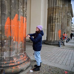Zwei Klimaaktivistinnen der Gruppe Letzte Generation bemalen am Donnerstag (16. November) das Brandenburger Tor mit oranger Farbe.