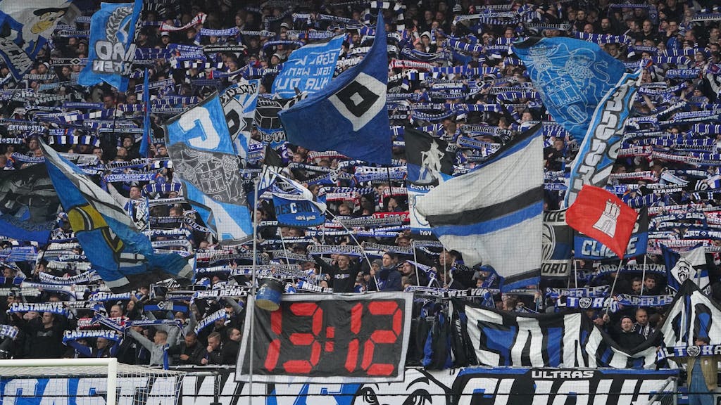 HSV-Fans halten Schals in die Höhe und schwenken Fahnen.