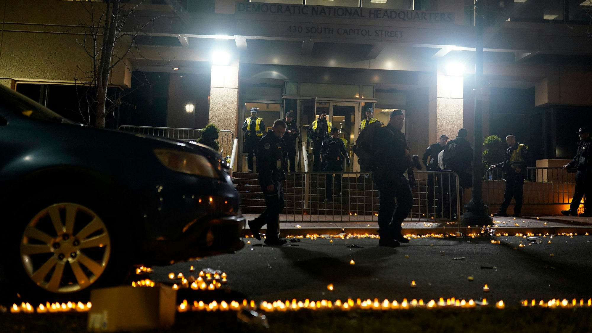 Angezündete Kerzen und Polizisten vor dem Headquarter der Demokraten in Washington (USA).