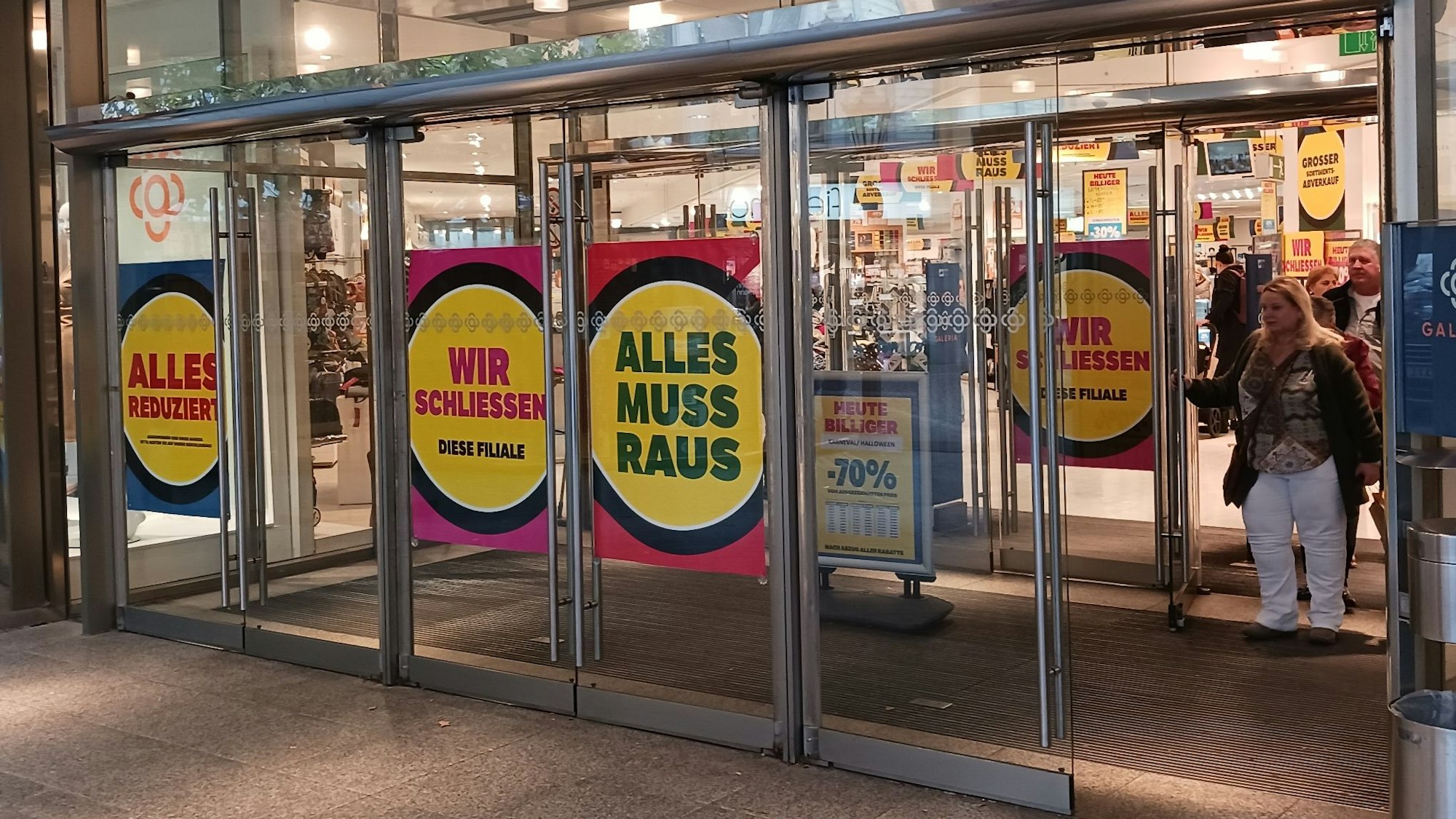 „Alles reduziert“, „Alles muss raus“, „Wir schließen“ steht auf Plakaten im Eingangsbereich des Siegburger Kaufhofs