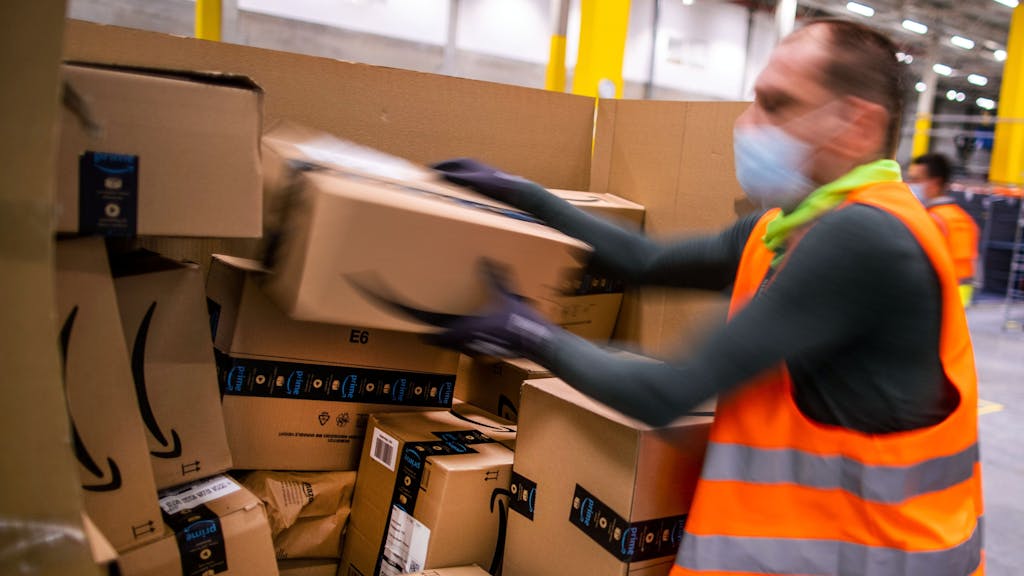 Ein Mitarbeiter sortiert an einem Transportband Paketsendungen in einem Verteilzentrum des Online-Händlers Amazon in Mecklenburg-Vorpommern.
