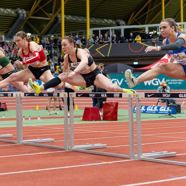 Das Bild zeigt fünf Sportlerinnen beim Hürdenlauf.&nbsp;