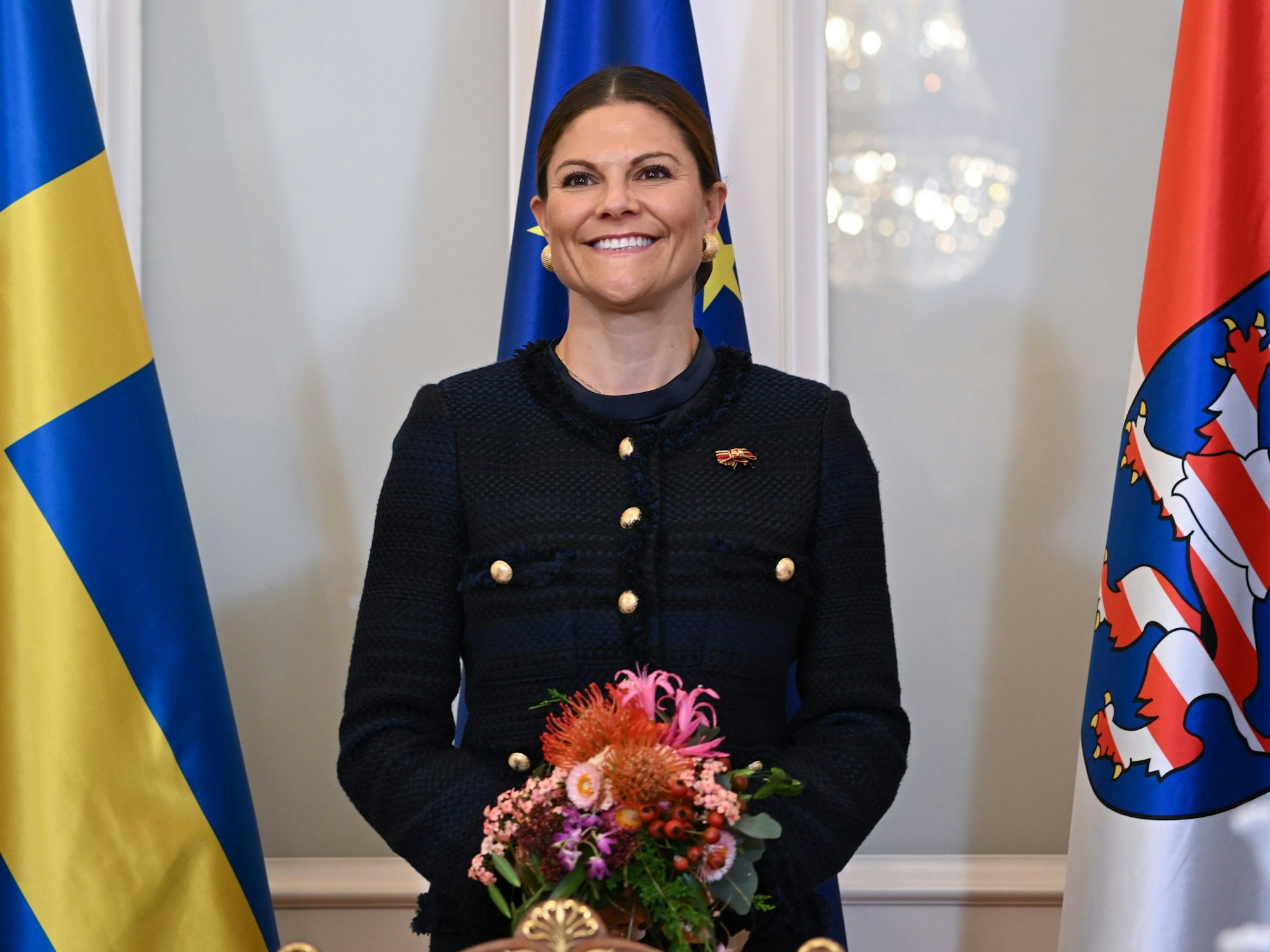 Kronprinzessin Victoria von Schweden steht bei ihrer Ankunft in der Hessischen Staatskanzlei vor den Flaggen Schwedens (l-r), Europas und Hessens.