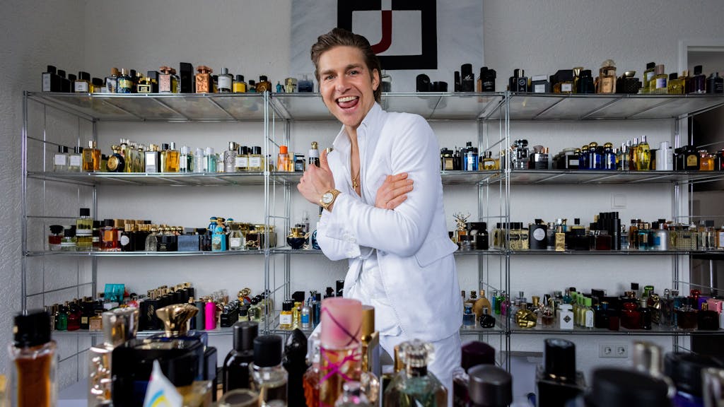Jeremy Fragrance, Unternehmer, Webvideoproduzent und Influencer, steht in seinem Büro zwischen Parfümfläschchen und posiert.&nbsp;