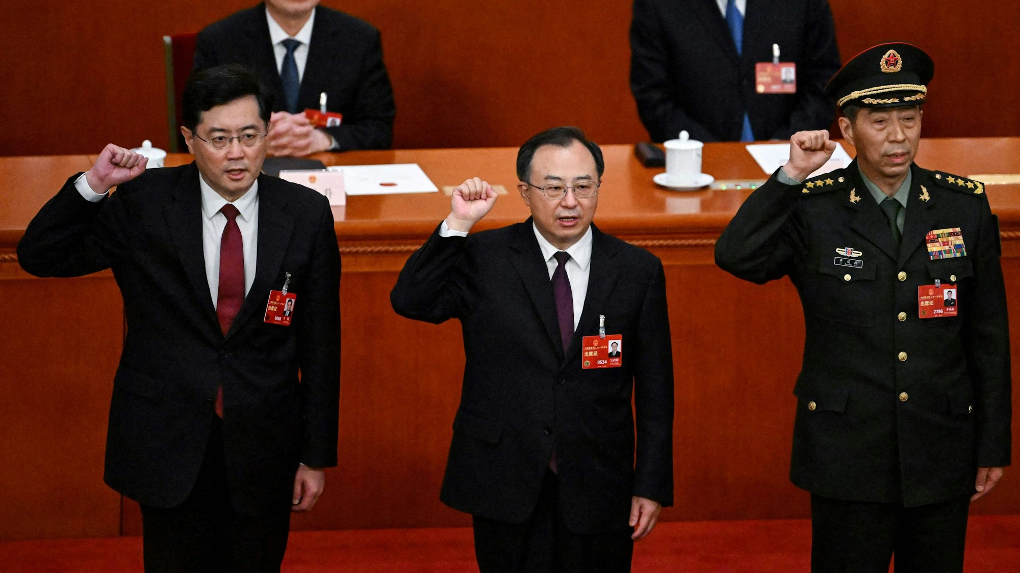 Die neu gewählten chinesischen Staatsräte Qin Gang (l) und Li Shangfu (r) legen am 12. März 2023 nach ihrer Wahl während der 5. Plenarsitzung des Nationalen Volkskongresses (NVK) in der Großen Halle des Volkes in Peking gemeinsam mit dem Staatsrat und dem Generalsekretär des Staatsrates Wu Zhenglong (C) den Amtseid ab.