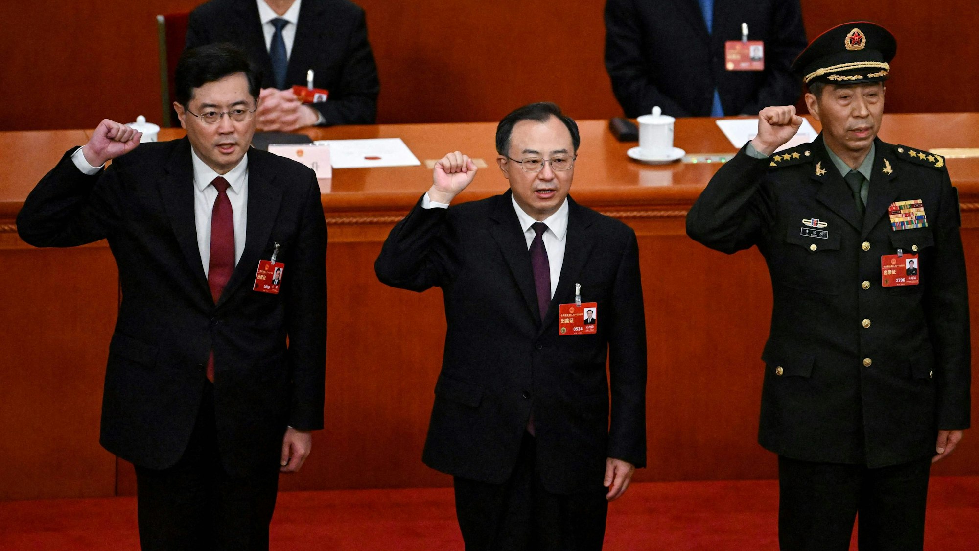 Die neu gewählten chinesischen Staatsräte Qin Gang (l) und Li Shangfu (r) legen am 12. März 2023 nach ihrer Wahl während der 5. Plenarsitzung des Nationalen Volkskongresses (NVK) in der Großen Halle des Volkes in Peking gemeinsam mit dem Staatsrat und dem Generalsekretär des Staatsrates Wu Zhenglong (m) den Amtseid ab.