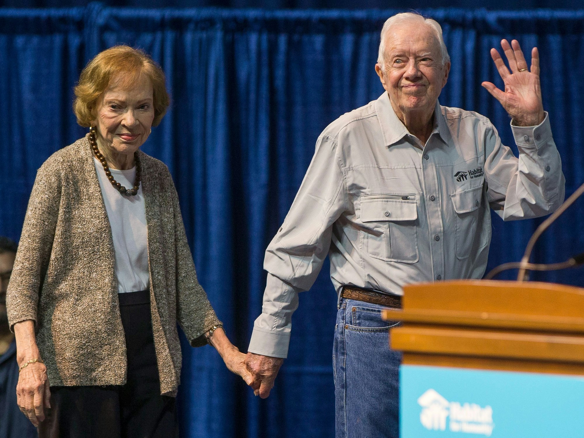 Der ehemalige US-Präsident Jimmy Carter winkt, als er mit seiner Frau Rosalynn Carter 2018 bei der Eröffnungsfeier des Jimmy & Rosalynn Carter Work Project im Purcell Pavillon der Universität Notre Dame in South Bend die Bühne betritt.