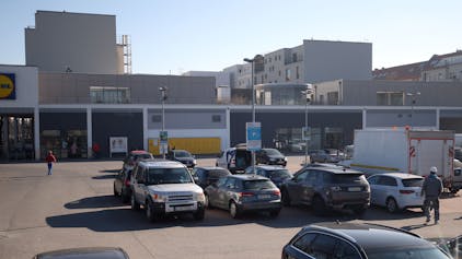 Autos stehen auf dem Parkplatz vor einer Lidl-Filiale.