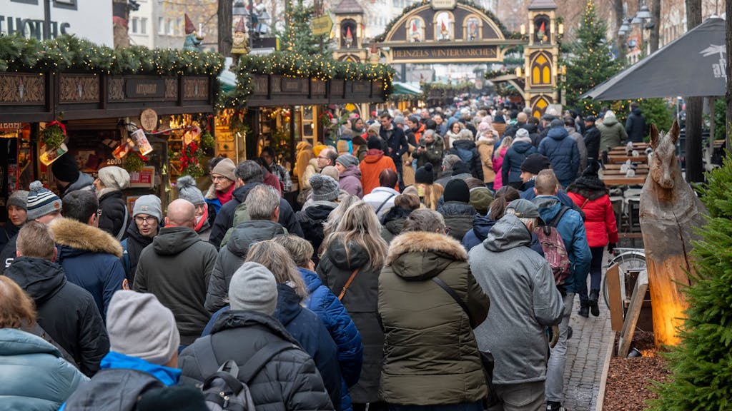 Besucher und Besucherinnen schlendern über den Weihnachtsmarkt auf dem Alter Markt.