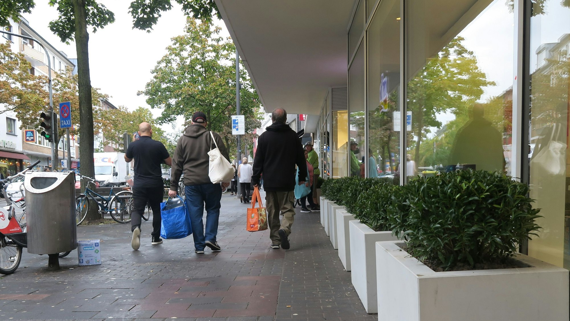 Einkaufende mit Tüten ziehen über die Kalker Hautpstraße.