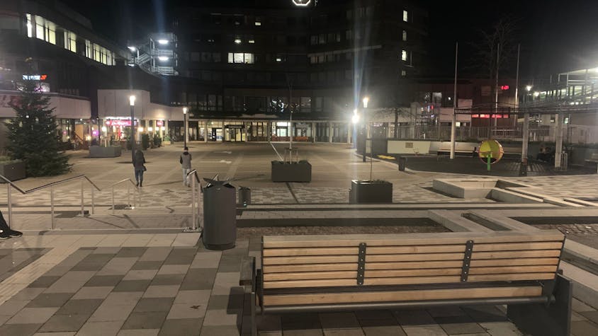 Der Karl-Gatzweiler-Platz am Abend ist öde und leer. Die Uhr am Rathaus in Sankt Augustin zeigt 18.40 Uhr an.