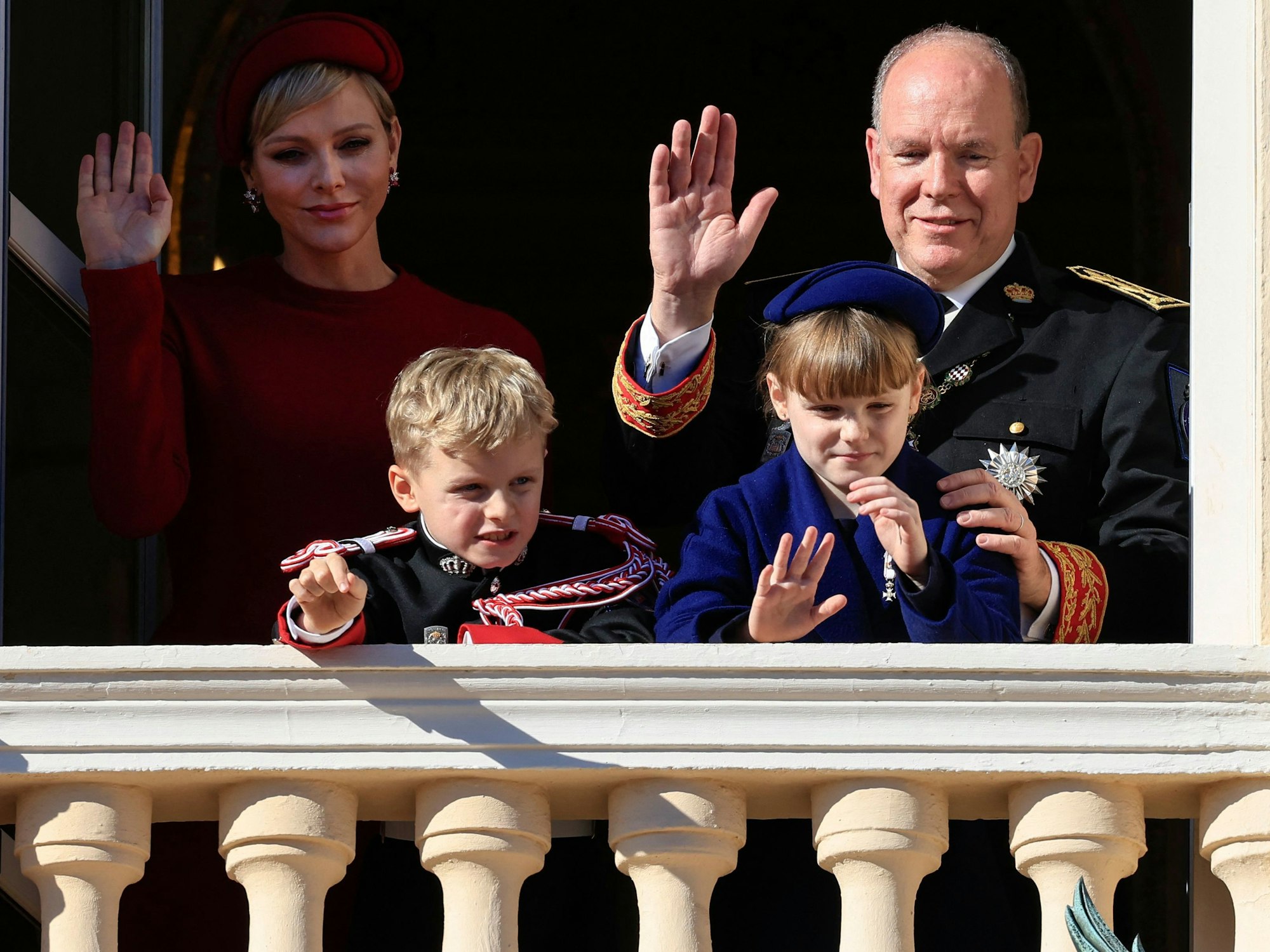 Fürstin Charlène von Monaco (hinten links), Fürst Albert II. von Monaco (hinten rechts), Fürst Jacques von Monaco (vorne links) und Fürstin Gabriella (vorne rechts) winken vom Balkon des Fürstenpalastes von Monaco während der Feier zum Nationalfeiertag.