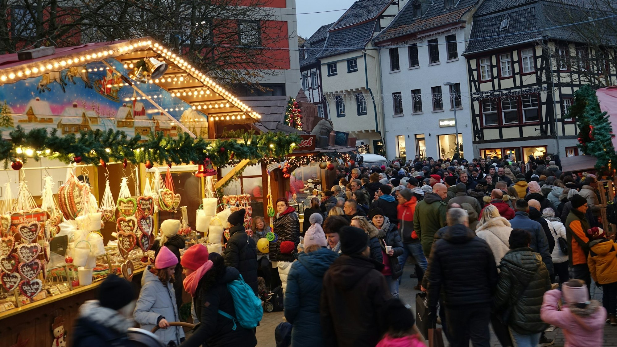 Der Weihnachtsmarkt in der historischen Altstadt mit beleuchteten Buden und vielen Menschen.