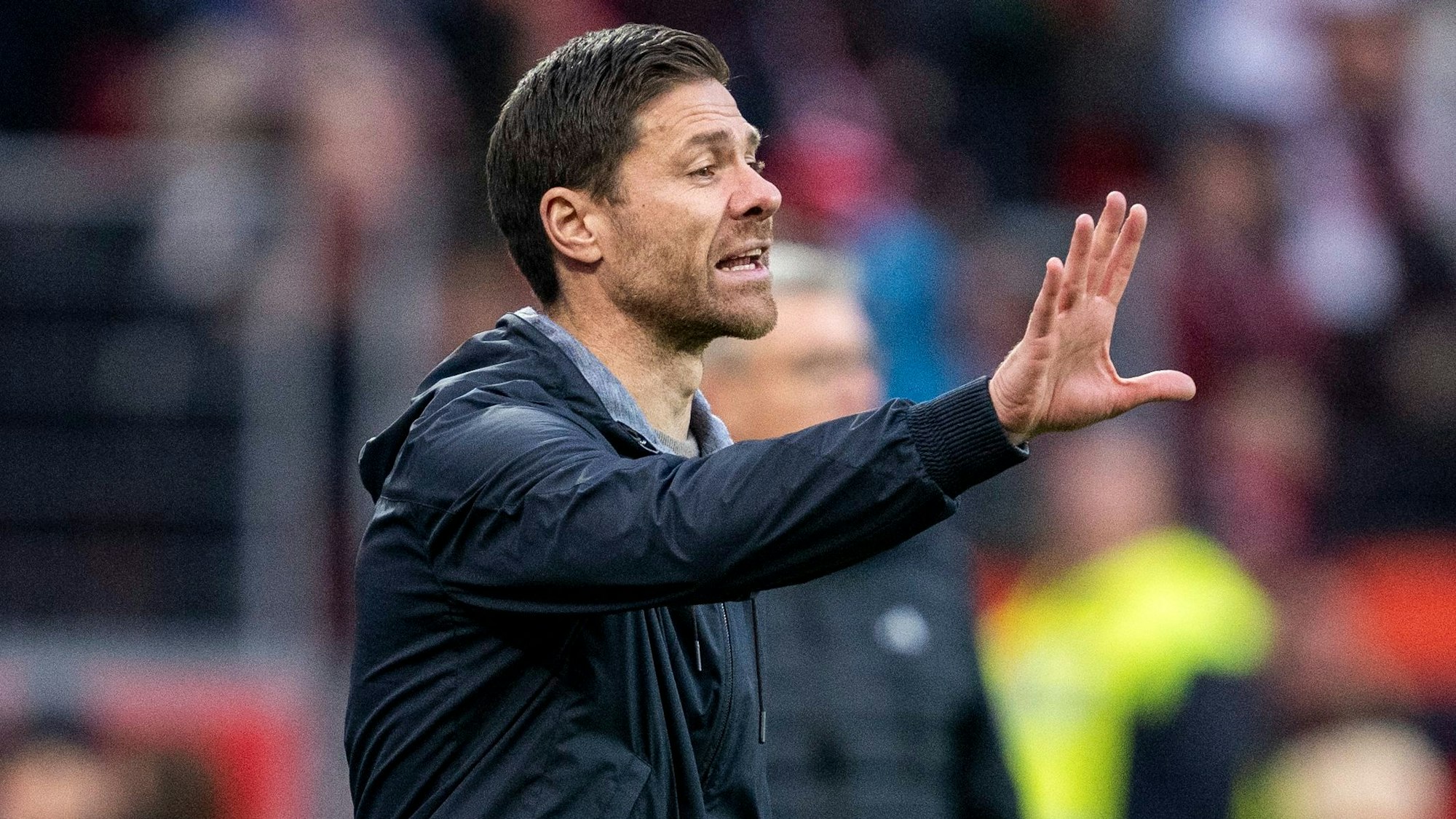 Bayer Leverkusens Trainer Xabi Alonso gibt Anweisungen bei einem Bundesliga-Spiel.