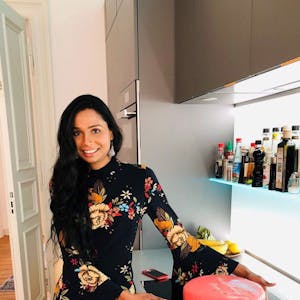 Eine Frau steht mit einer Torte in ihrer Küche