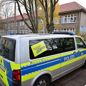 17.11.2023, Thüringen, Erfurt: Polizeifahrzeuge stehen vor der Erfurter Grundschule am Schwemmbach. Nach Drohungen überprüft die Polizei zwei Erfurter Schulen. An den Schulen sind nach Angaben der Polizei Mails mit Bombendrohungen eingegangen. Foto: Martin Schutt/dpa +++ dpa-Bildfunk +++