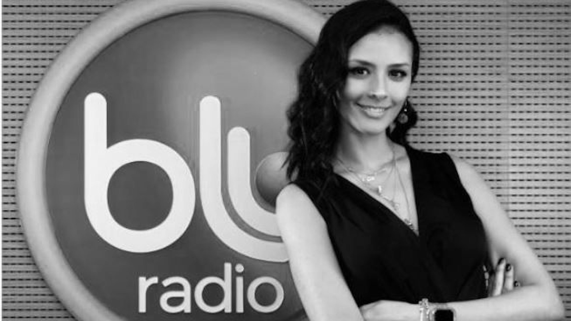Die Radio-Moderatorin Luz Piedad Eusse posiert vor dem Logo ihres Senders.