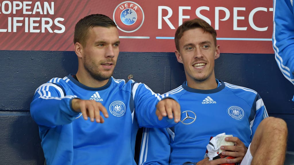 Lukas Podolski und Max Kruse (r.) sitzen bei einem Spiel der deutschen Nationalmannschaft auf der Bank.&nbsp;