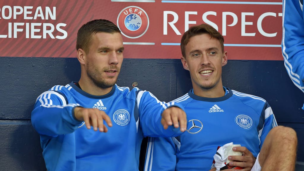 Lukas Podolski und Max Kruse (r.) sitzen bei einem Spiel der deutschen Nationalmannschaft auf der Bank.&nbsp;