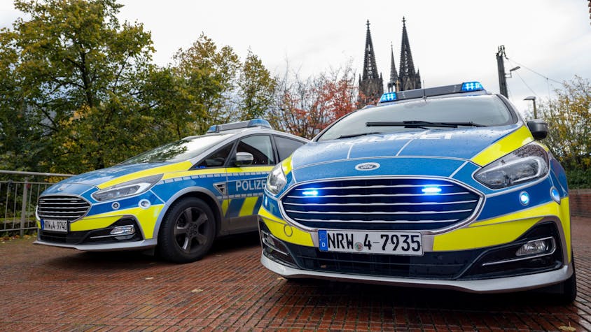 Das Foto zeigt zwei Polizeiwagen vor dem Kölner Dom.