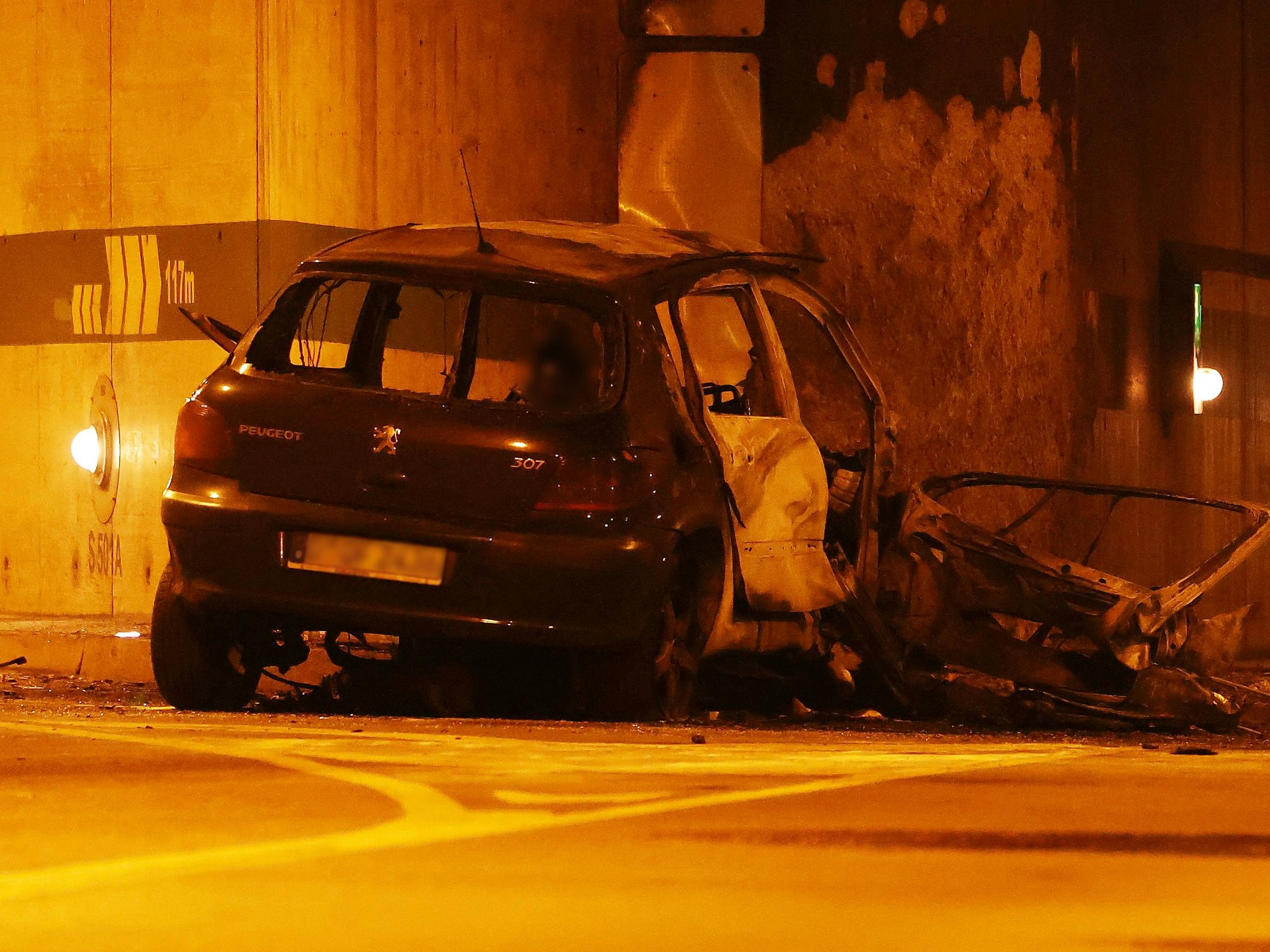 Ein beschädigtes Fahrzeug steht nach einem Unfall an einer Wand.