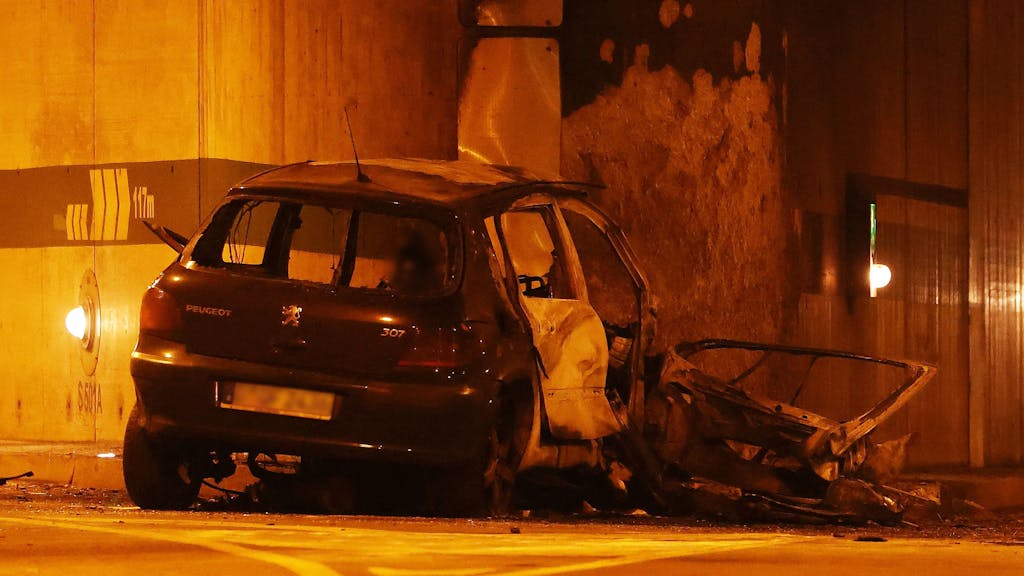 Ein beschädigtes Fahrzeug steht nach einem Unfall an einer Wand.