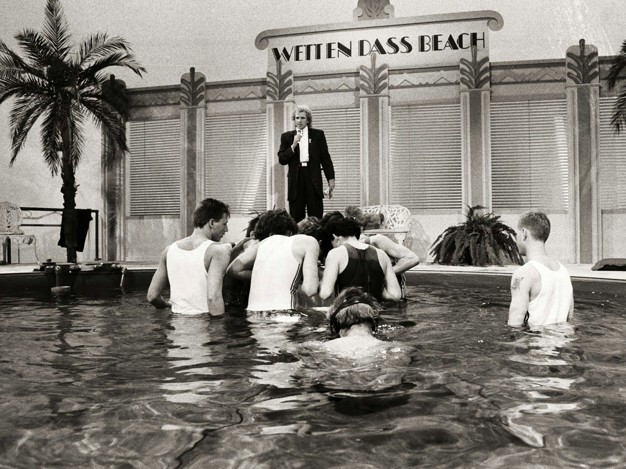 Mehrere Personen im Pool bei der Badekappen-Wette.