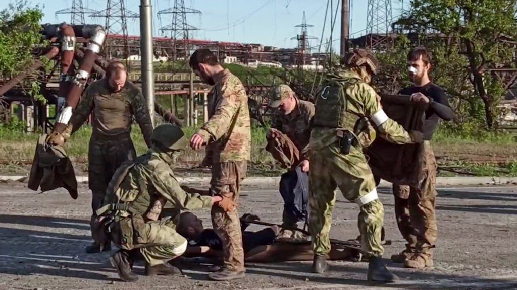 Das Archivfoto aus einem vom russischen Verteidigungsministerium im Mai 2022 veröffentlichten Video zeigt ukrainische Militärangehörige, die nach dem Verlassen des belagerten Stahlwerks Asowstal von prorussischem Militärpersonal durchsucht werden.