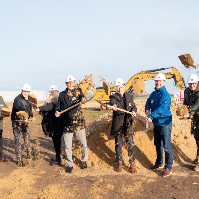 Mehrere Männer und eine Frau schaufeln mit Spaten losen Sand und werfen ihn in die Höhe. In der Mitte steht Ulf Hürtgen, Bürgermeister der Stadt Zülpich.