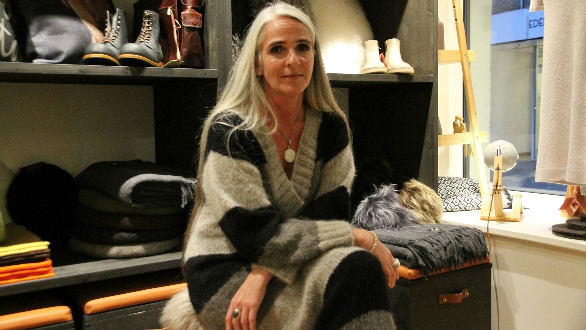 Eine Frau vor Regalen mit Schuhen und Kleidung in ihrem Geschäft