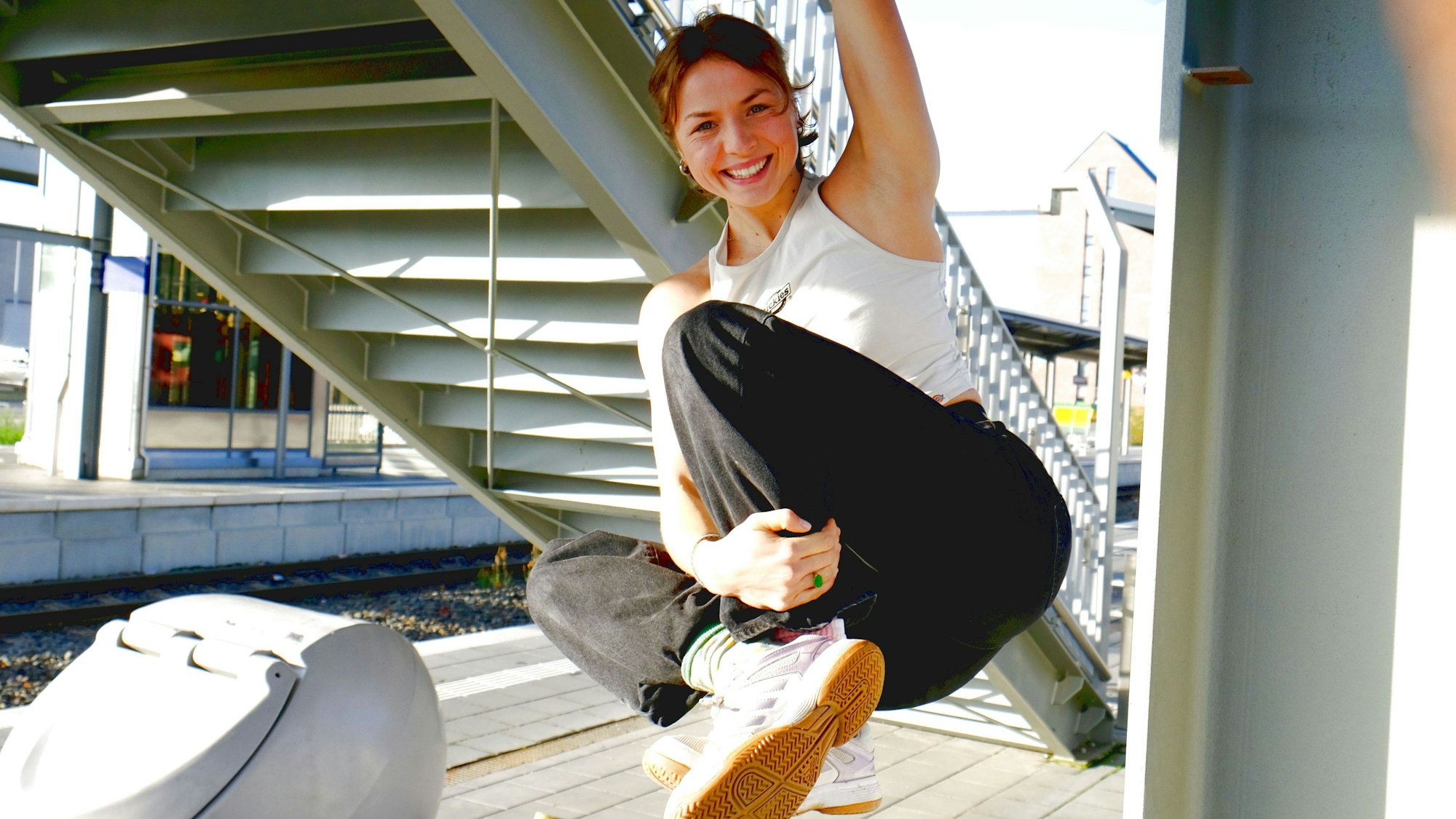 Ada Theilken demonstriert ihre Kletterkünste und hängt an einem Arm an einer Brücke am Bahnhof Mechernich.
