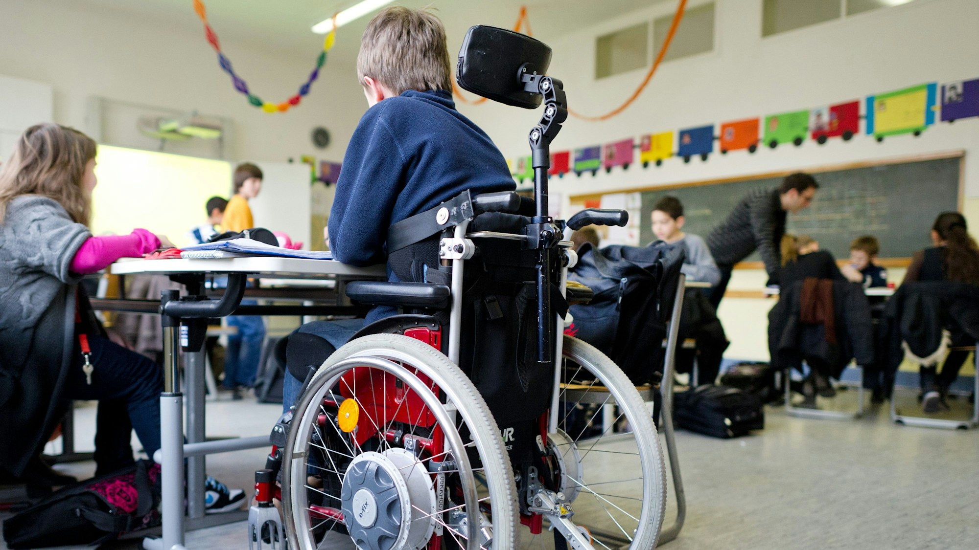 Eine Junge im Rollstuhl in einem Klassenzimmer.