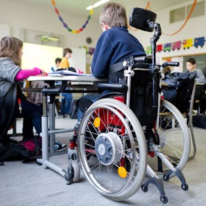 Ein Junge im Rollstuhl sitzt in einem Klassenzimmer.