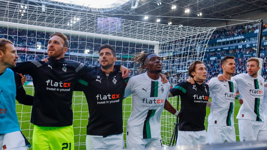 Spieler von Borussia Mönchengladbach hüpfen und feiern mit den Fans.