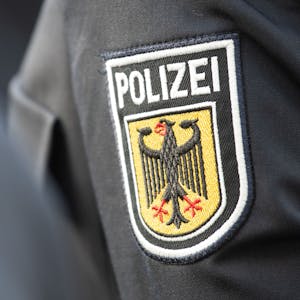 Junge Bundespolizistinnen und Polizisten stehen bei ihrer Vereidigung im Innenhof der Bundespolizeiinspektion am Flughafen Frankfurt, dabei ist ein Polizeiabzeichen auf einem Ärmel zu sehen.&nbsp;