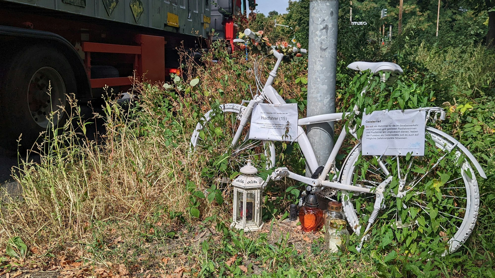 Auf dem Foto ist ein Geisterrad in Hürth zu sehen. Es ist weiß lackiert. Es erinnert an den 15-jährigen Radfahrer, der dort im Dezember 2021 von einem abbiegenden Lkw überrollt und getötet wurde.