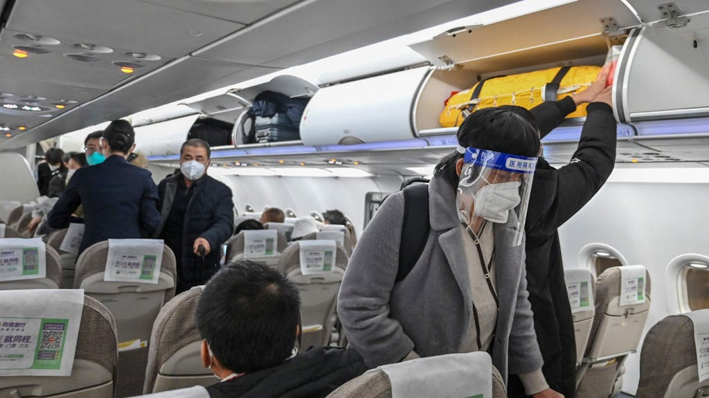 Ein Passagier, der inmitten der Covid-19-Pandemie im Januar 2023 Gesichtsschutz und eine Maske trägt, besteigt einen Inlandsflug am internationalen Flughafen in Shanghai.&nbsp;