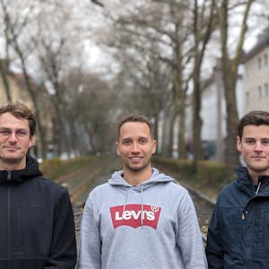 Max Krumm, Geronimo Pfeffer und Michel Sayn stehen auf einer Straße in Köln.&nbsp;