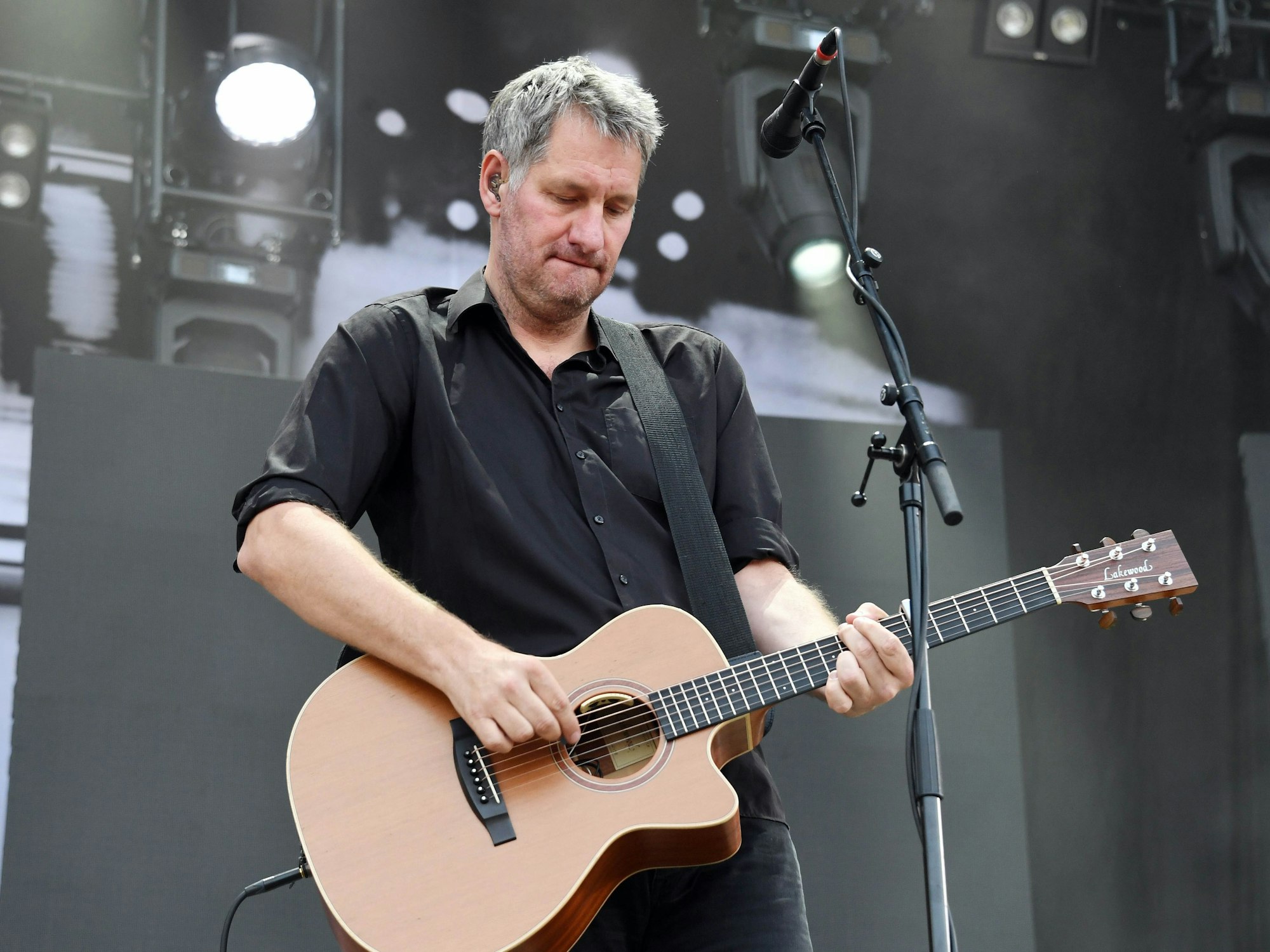 Sänger Marcus Wiebusch von Kettcar spielt Gitarre auf der Bühne.