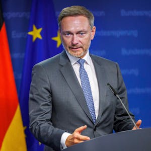 Bundesfinanzminister Christian Lindner (FDP) steht an einem Rednerpult, im Hintergrund sind Deutschland- und Europaflagge zu sehen.