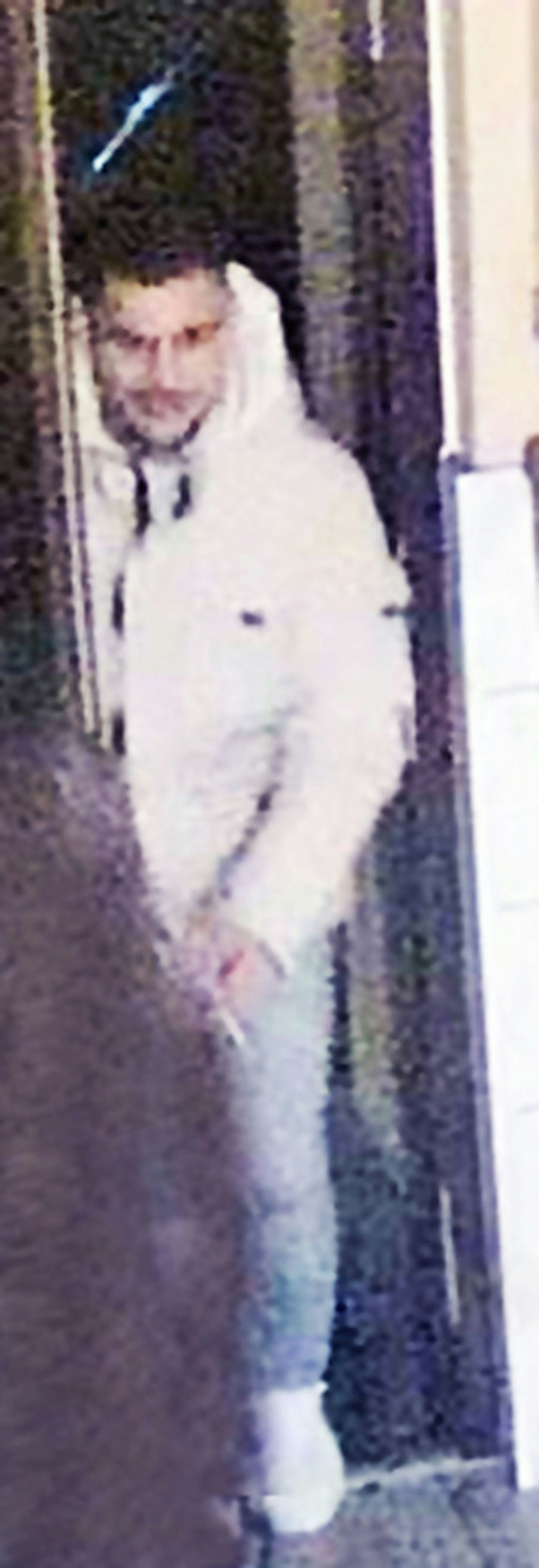 Ganzkörperfoto eines Mannes in heller Kleidung, er wird von der Polizei gesucht.