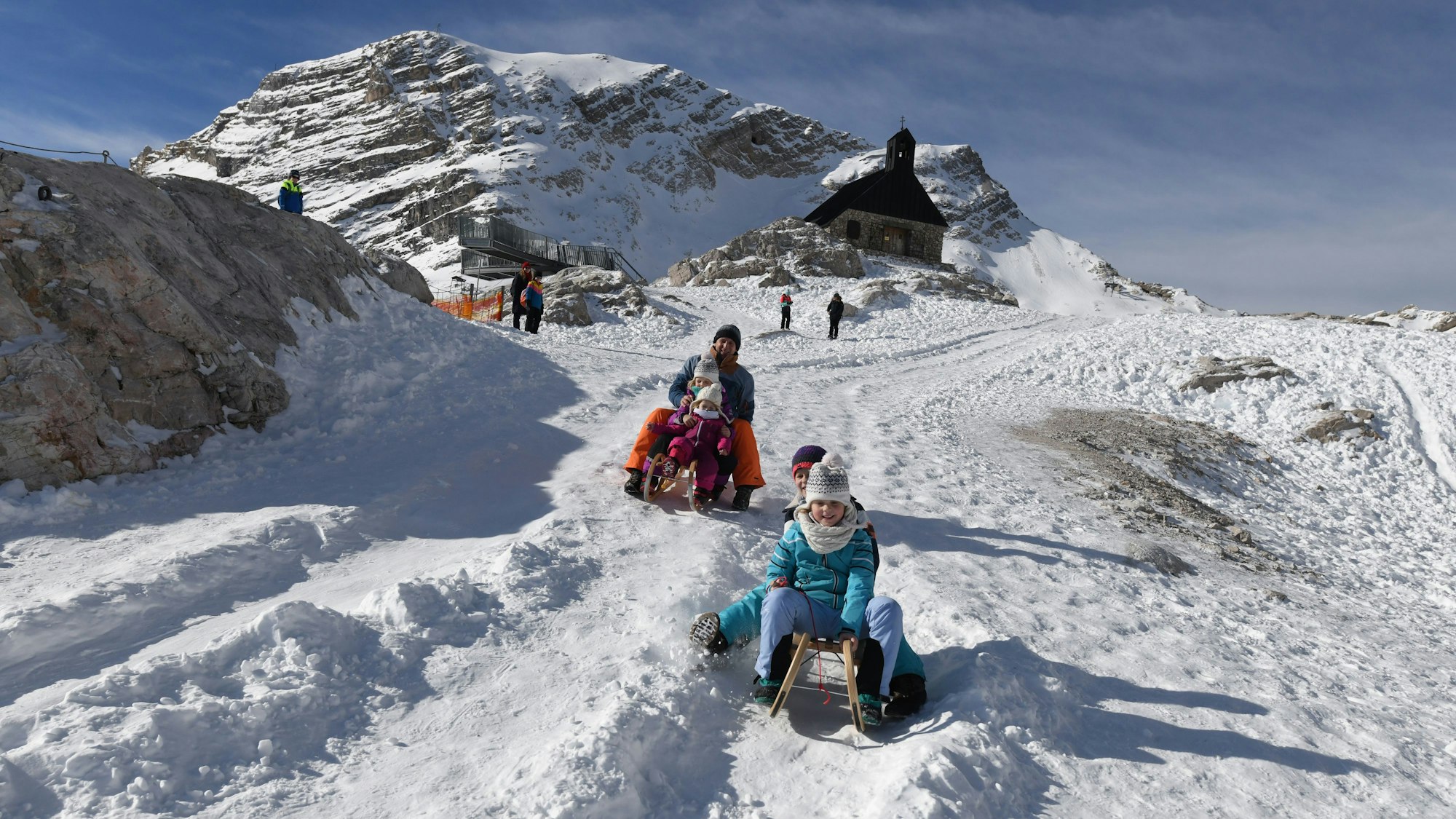 Eine Familie nutzt den frischen Schnee am Zugspitzplatt zum Rodeln. (Archivbild)