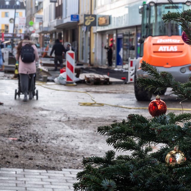 Das Bild zeigt die Euskirchener Fußgängerzone. Am rechten Bildrand ist ein Weihnachtsbaum zu sehen, im Hintergrund die Baustelle an der Neustraße.