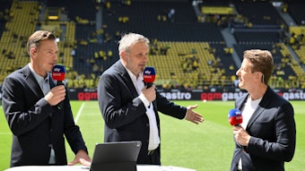 Erik Meijer, Didi Hamann und Michael Leopold stehen am Spielfeldrand in Dortmund.