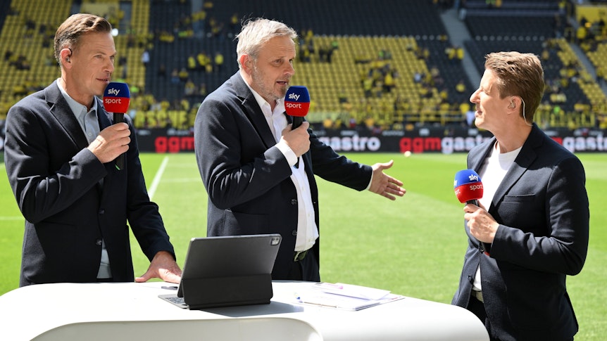 Erik Meijer, Didi Hamann und Michael Leopold stehen am Spielfeldrand in Dortmund.