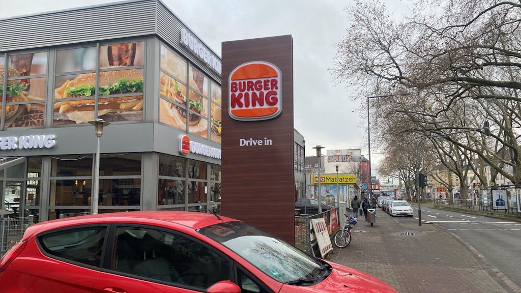 Ein Auto fährt aus einem Drive-In bei einer Burger-King-Filiale in Köln.