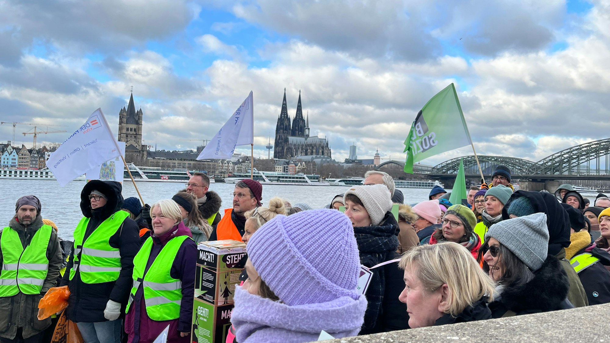 Mitarbeitende der sozialen Träger protestierten am Rheinufer in Deutz dagegen, dass die Stadt Köln die Tariferhöhungen im öffentlichen Dienst nicht an sie weiterreichen will. Im Hintergrund der Kölner Dom.