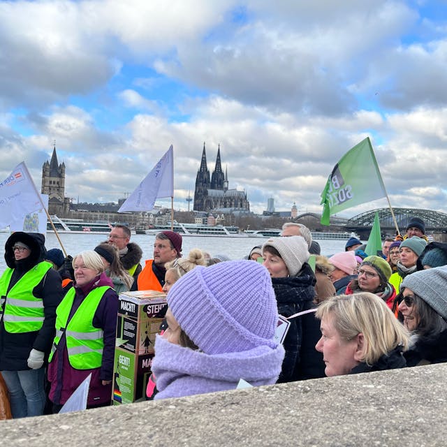 Mitarbeitende der sozialen Träger protestierten am Rheinufer in Deutz dagegen, dass die Stadt Köln die Tariferhöhungen im öffentlichen Dienst nicht an sie weiterreichen will. Im Hintergrund der Kölner Dom.