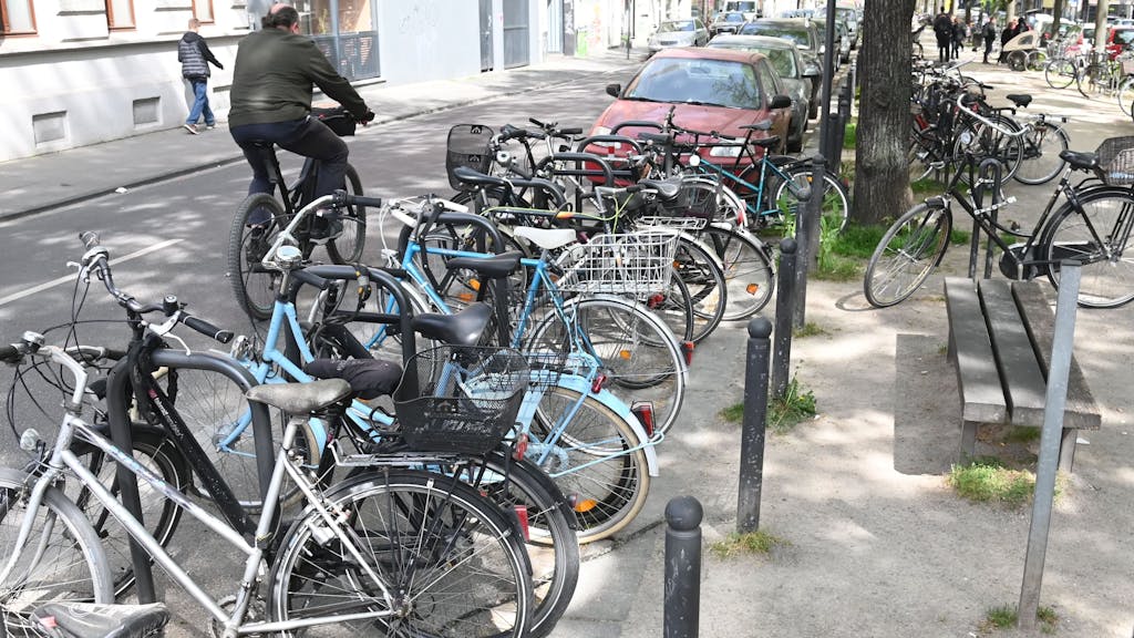 Auf einer Straße in Köln sind dutzende Fahrräder am Straßenrand zu sehen.&nbsp;